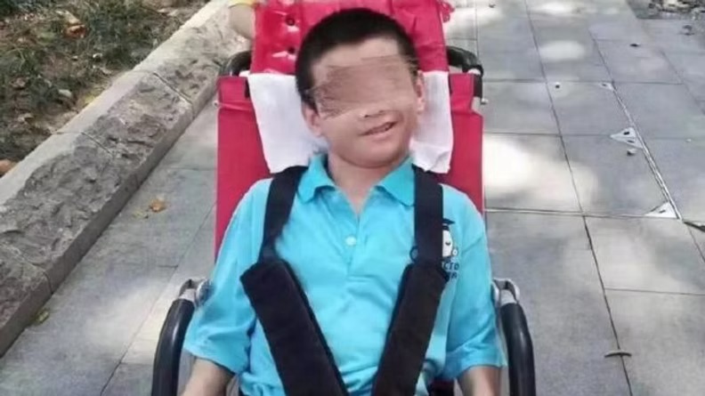 Chinese boy in a wheel chair, blurred face